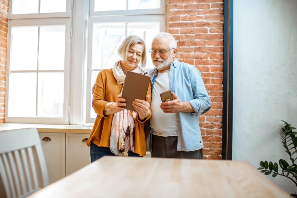 Elderly couple showing each other their iPad screens