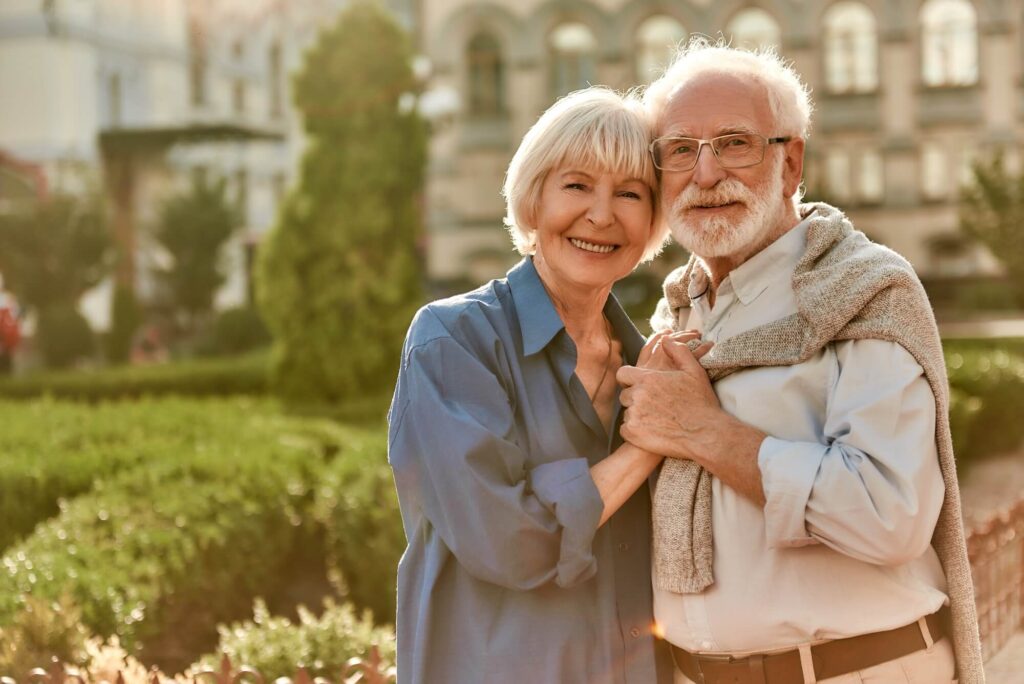 Elderly couple posing for a photo hand in hand