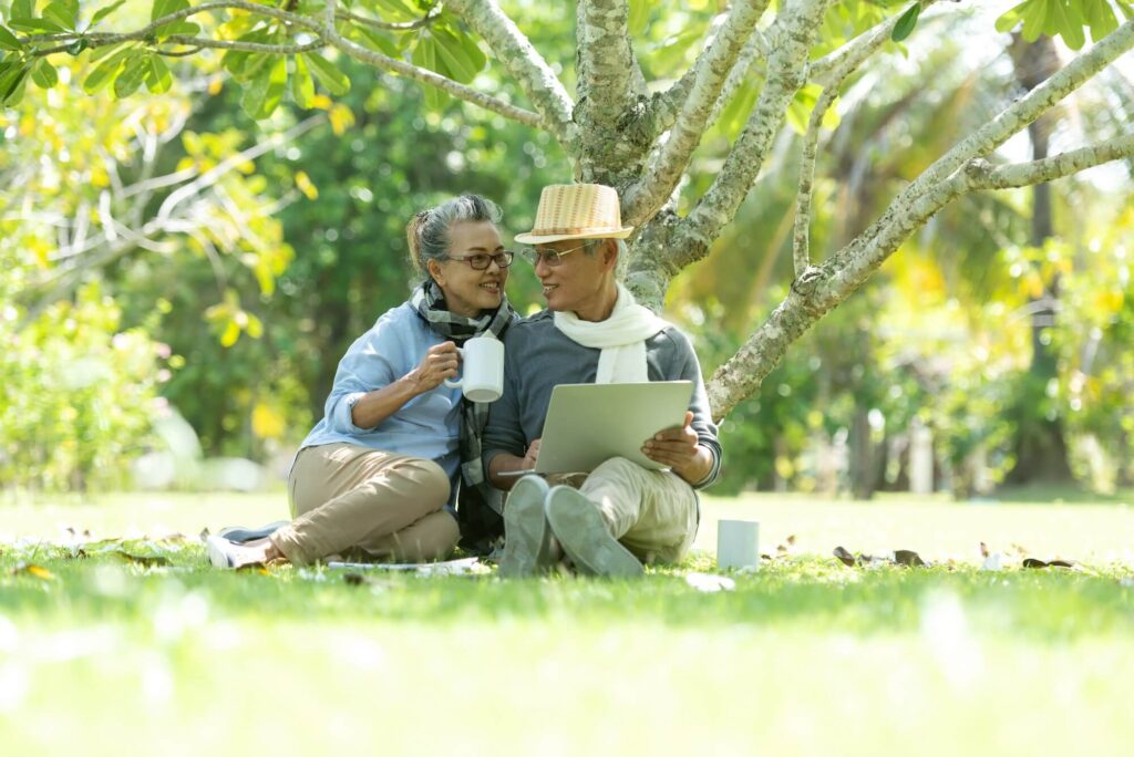 Couple relaxing in nature under a tree in the sunshine