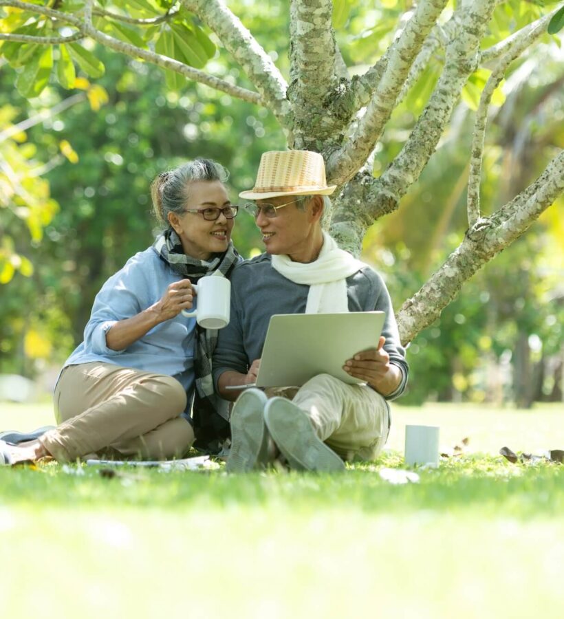 Couple relaxing in nature under a tree in the sunshine