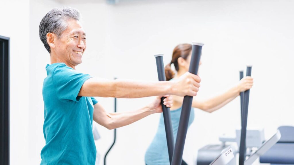 Elderly gentleman enjoying exercising on gym equipment